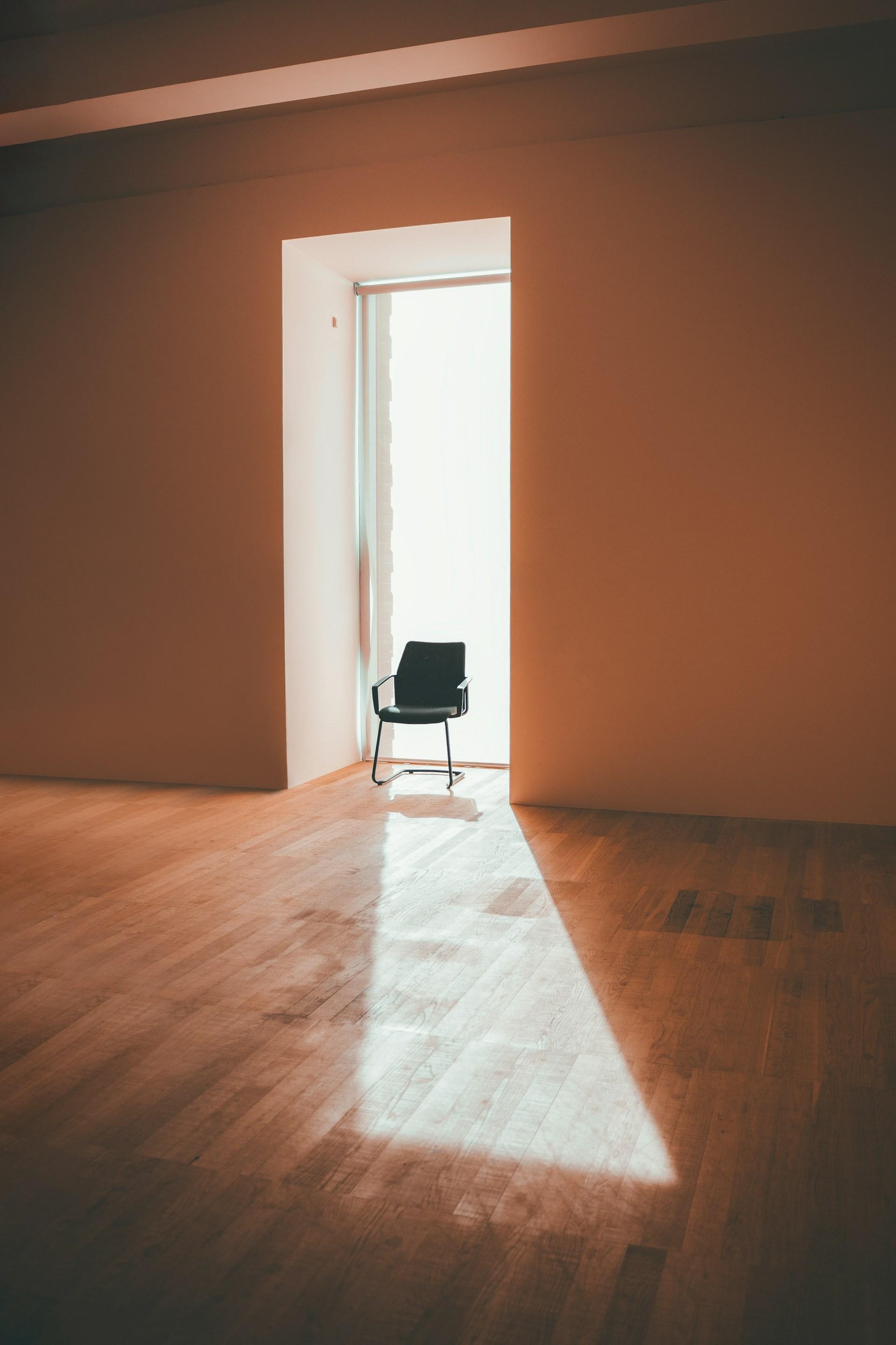 Lichte, lege ruimte met strak afgewerkte wanden en een houten vloer